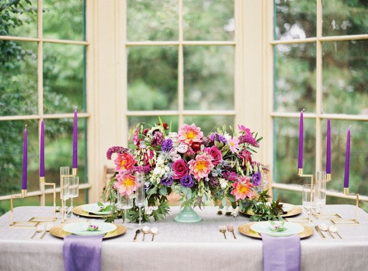 purple gold and pink wedding centerpiece with candles and greenery