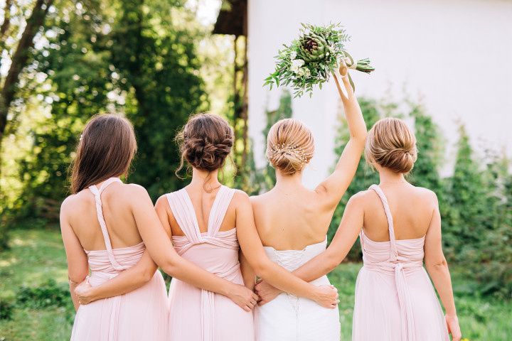 bridesmaids in pink dresses backs turned