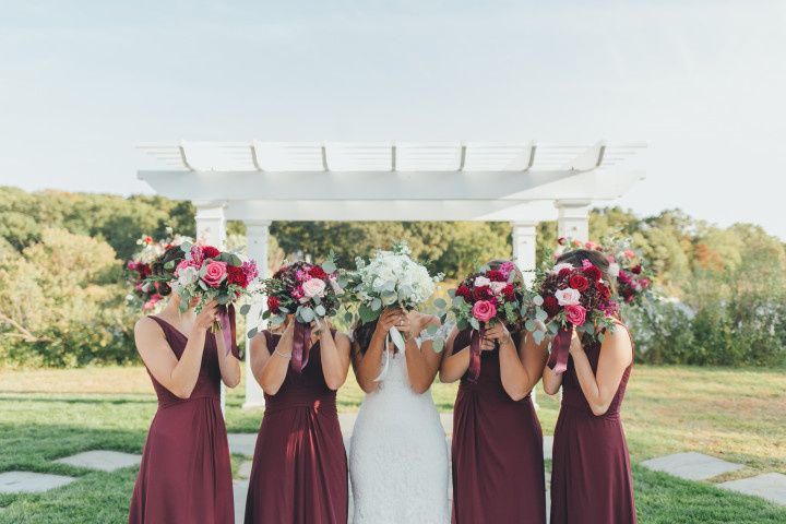 bridesmaids with bouquets covering faces