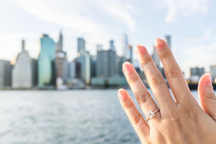 woman with engagement ring looking at nyc skyline
