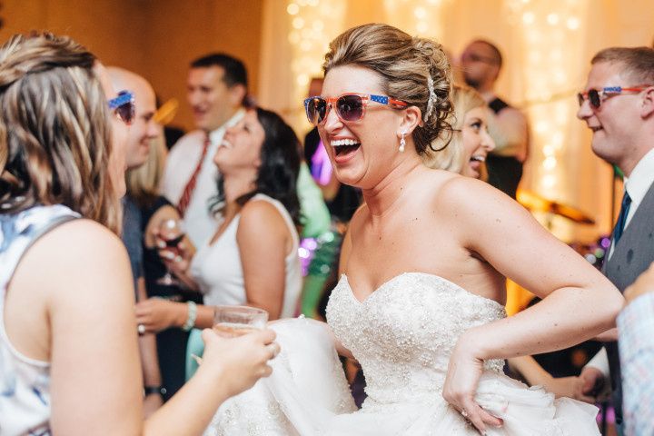 bride wearing sunglasses and dancing at wedding