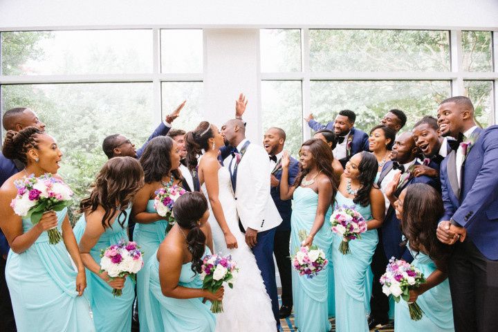 wedding party watching couple kiss and cheering