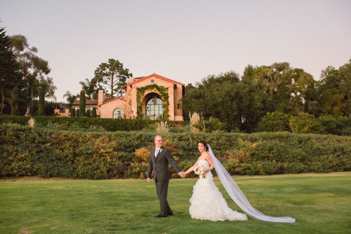 bride and groom walk and hold hands at outdoor garden wedding venue in Santa Barbara