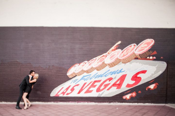 couple kiss during engagement shoot in front of Las Vegas street art