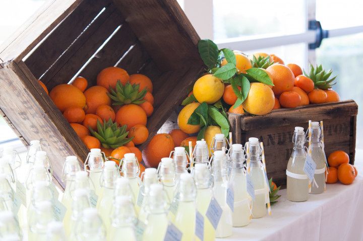 wedding favors on a table decorated with wooden crates and oranges