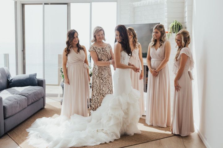 bride in wedding dress surrounded by bridesmaids