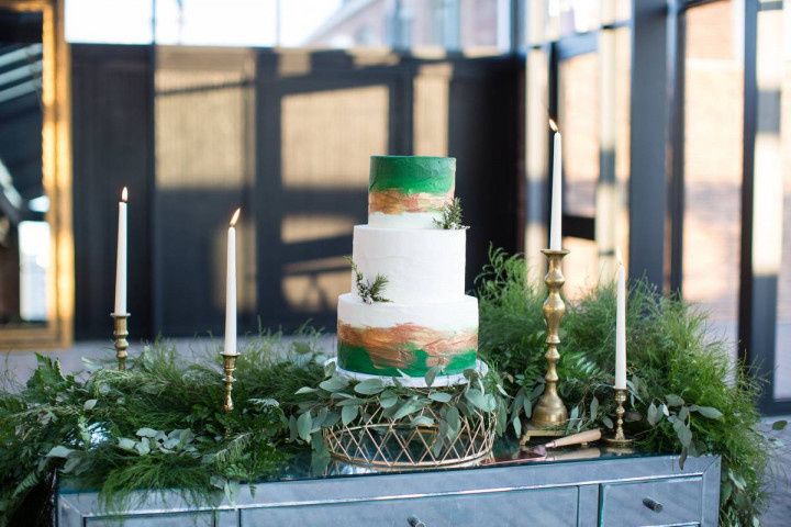 three-tier wedding cake decorated with abstract green and gold edible paint