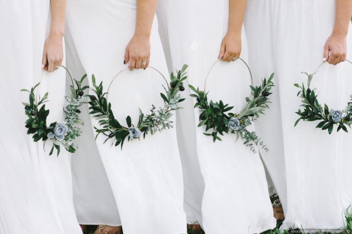 bridesmaids wearing white dresses carrying wreaths
