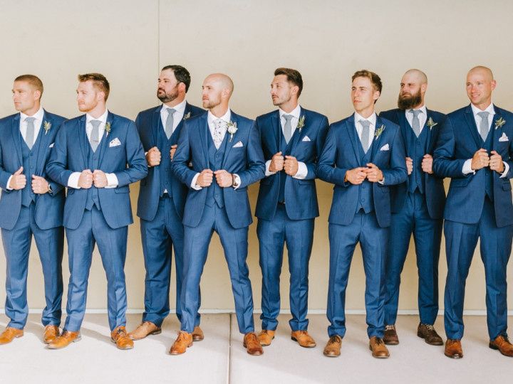 groom and groomsmen wearing blue three-piece suits and brown shoes