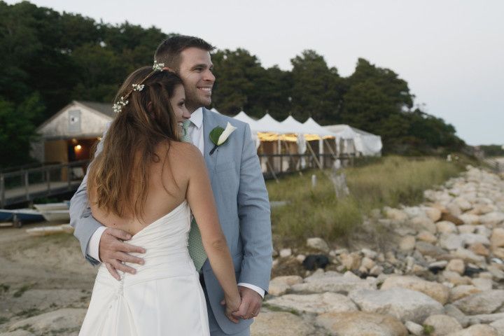 couple standing on rocks overlooking beach candid portrait 