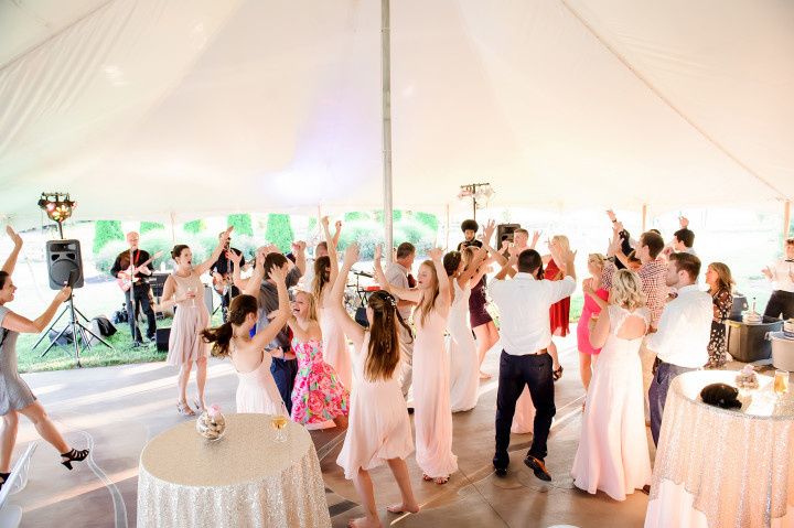 wedding guests dancing with hands raised in the air