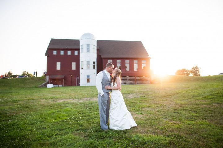 wedding couple kissing in front of barn