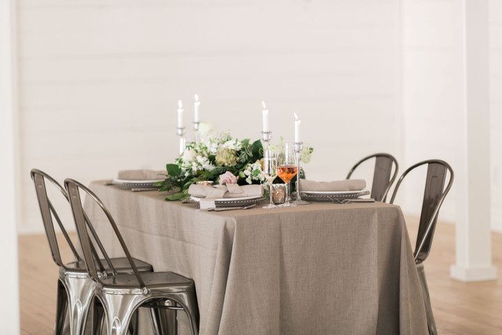 rustic farmhouse style wedding tablescape with neutral linens and blush and white centerpiece