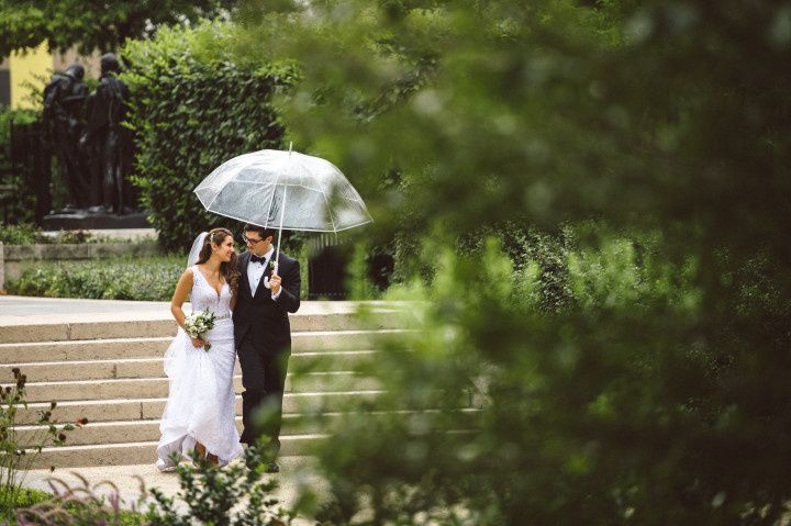 couple walking with umbrella rainy day wedding 