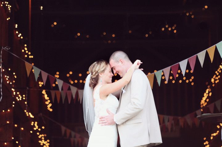 couple in front of barn and bunting 