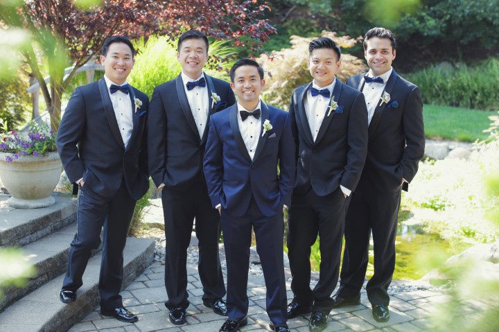 groom and groomsmen wearing blue tuxedos and bow ties