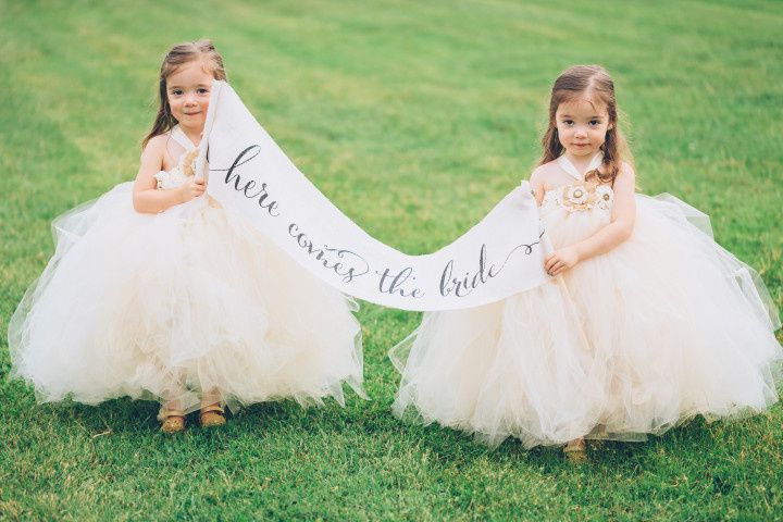 flower girls holding banner sign 