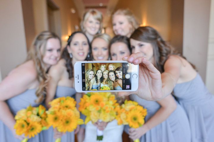 bride with bridesmaids taking selfie
