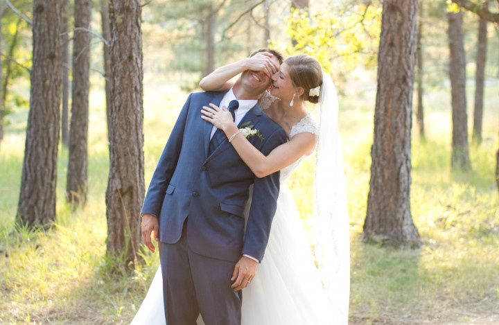 Bride covering groom's eyes outdoors