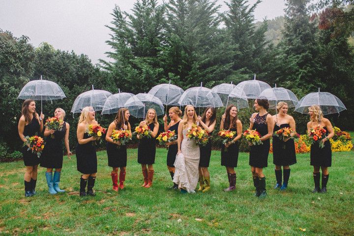 bride and bridesmaids with umbrellas and rain boots