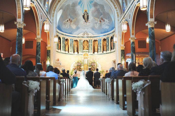 couple and wedding party kneeling at altar traditional catholic ceremony