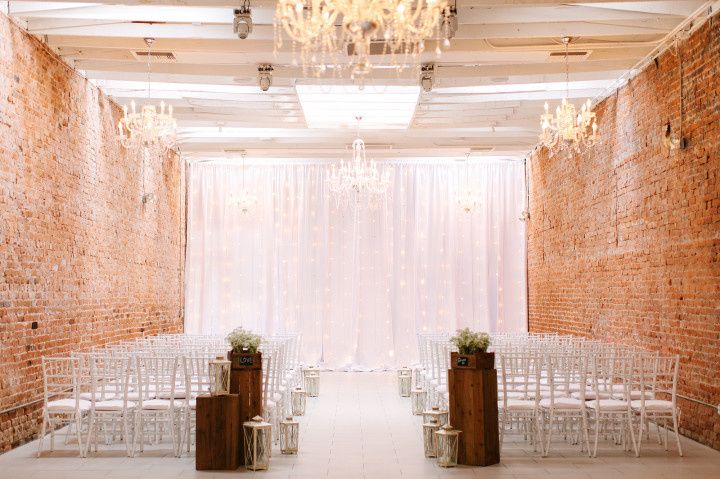 loft ceremony space string lights linen backdrop rustic white chiavari chairs aisle markers 