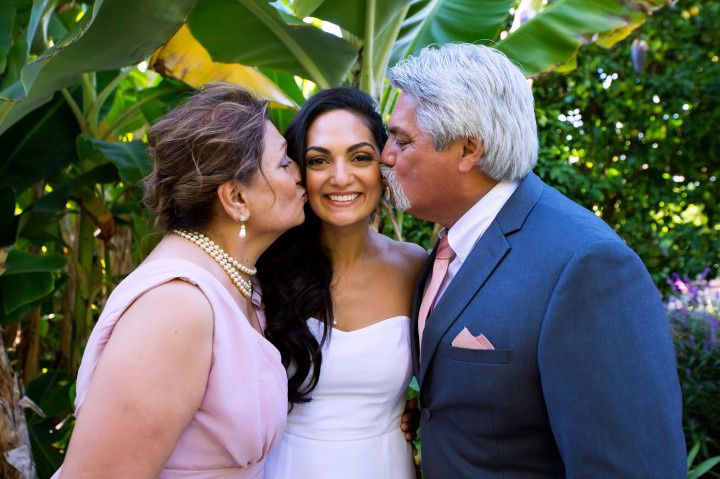 parents kissing bride