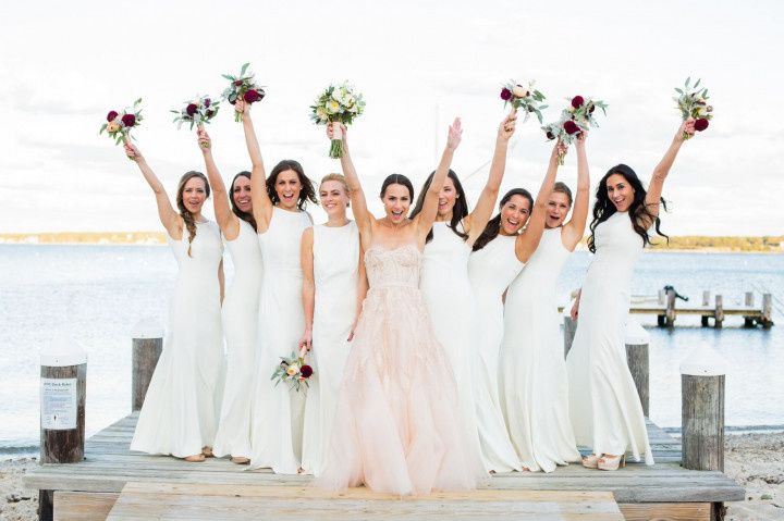 bride wearing pink dress bridesmaids wearing white dresses 
