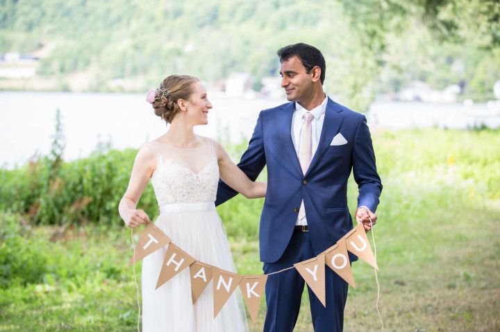 wedding couple holding thank you banner 