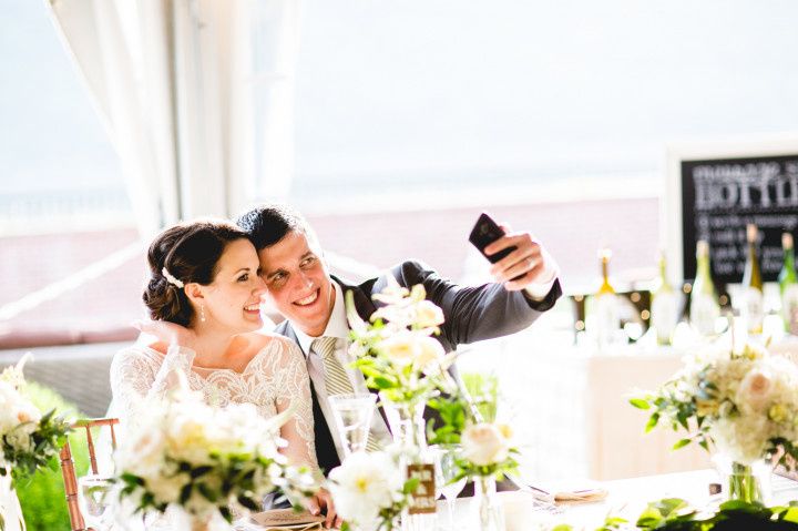 couple taking selfie at wedding reception 