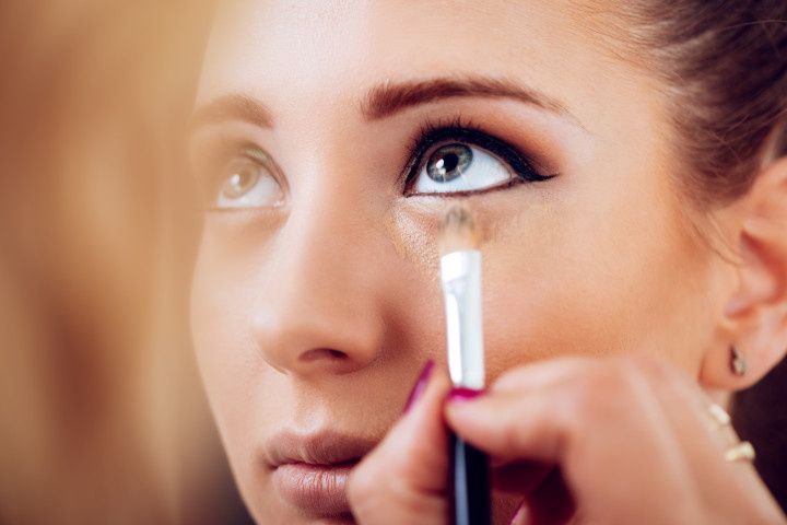woman putting on concealer