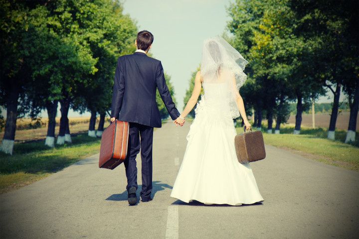 bride and groom with suitcases