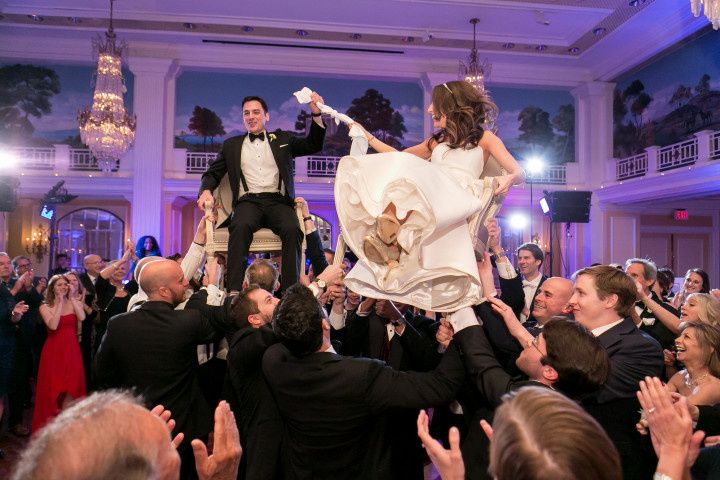 couple lifted on chairs dance floor hora 