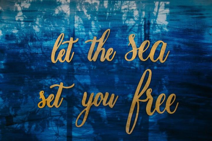 wedding sign with blue watercolor backdrop and gold calligraphy that reads