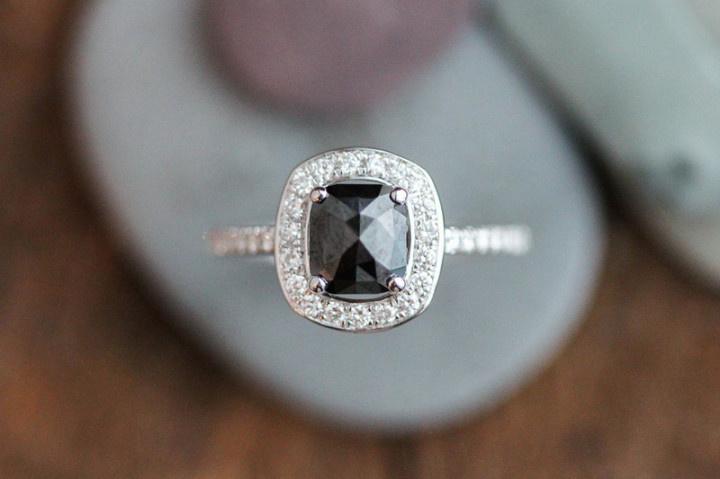 black engagement ring with cushion-cut onyx and diamond halo setting