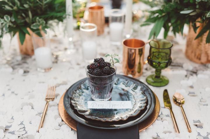 wedding place setting with gold flatware and fresh blackberries