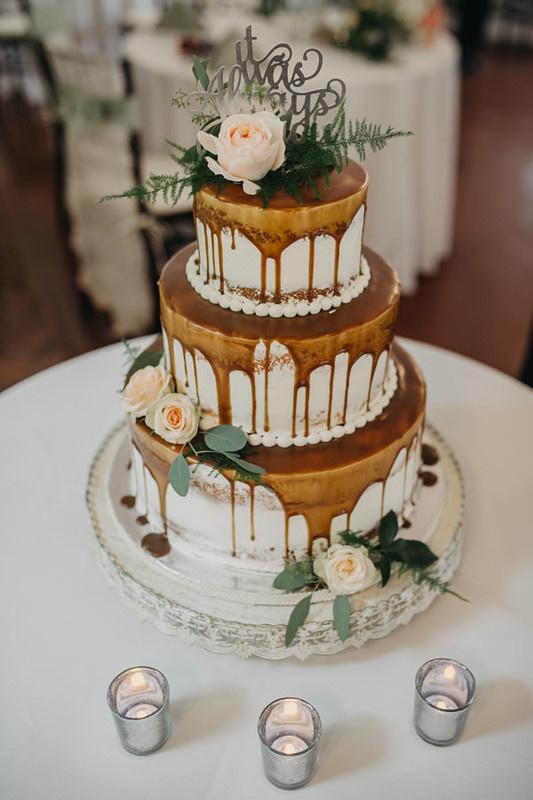 drip wedding cake decorated with caramel icing and flowers