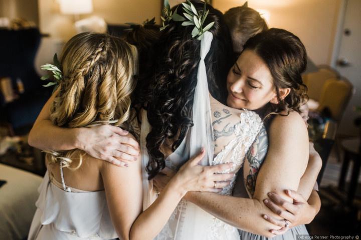 bridesmaids hugging bride