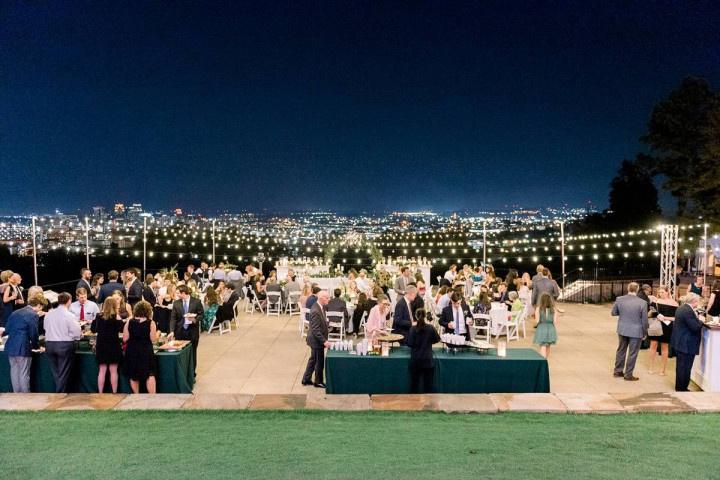 outdoor wedding reception at night overlooking birmingham skyline with string lights and dance floor