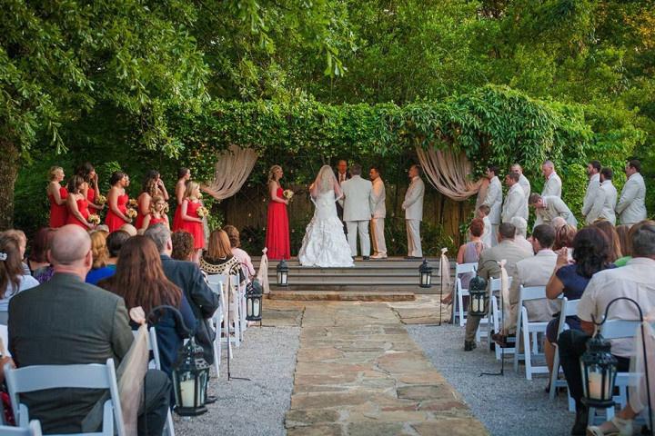 bride and groom stand in ivy covered courtyard for outdoor wedding ceremony