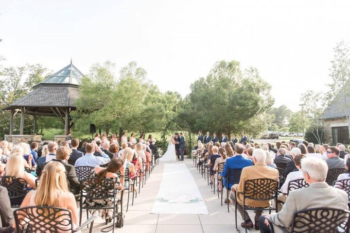 guests watch outdoor wedding ceremony in garden patio