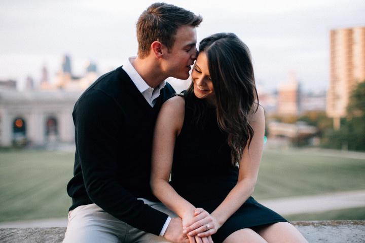 engagement photo man whispering in woman's ear 