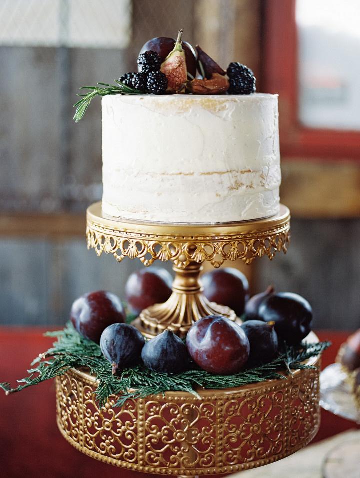 single tiered semi naked cake on two tiered vintage cake stand with fruit 
