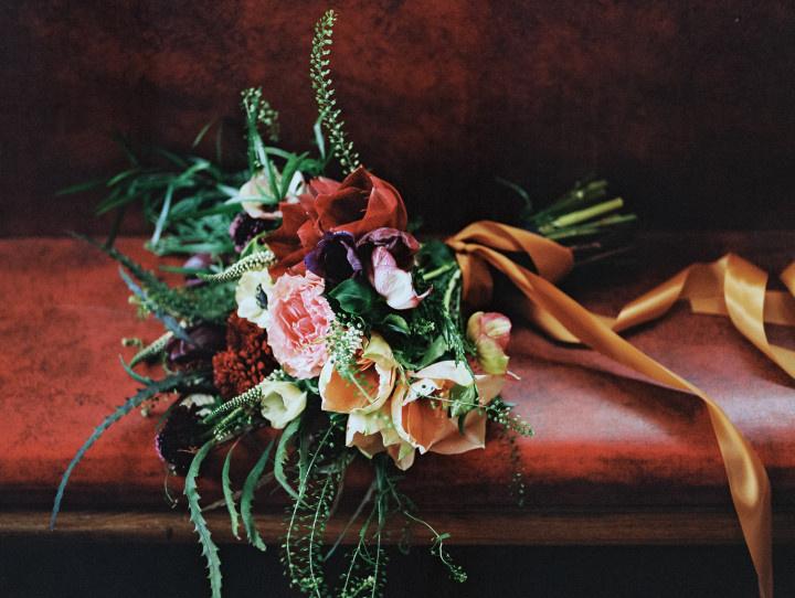 winter bouquet featuring peonies roses and mums on a velvet bench 