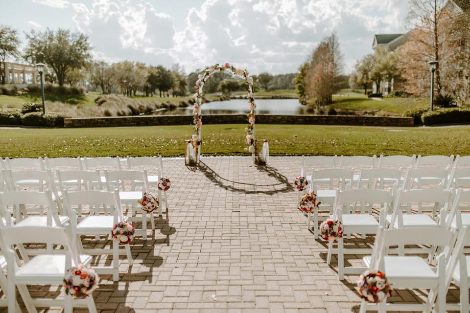 romantic outdoor wedding aisle decor idea floral pomanders hanging on the sides of chairs down the aisle