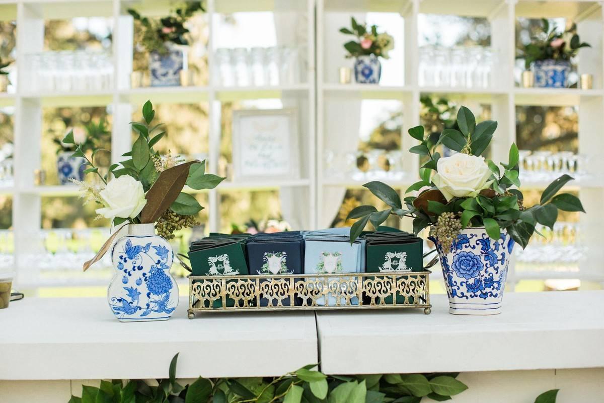 basket of koozies on a wedding favor table decorated with blue and white chinoiserie vases