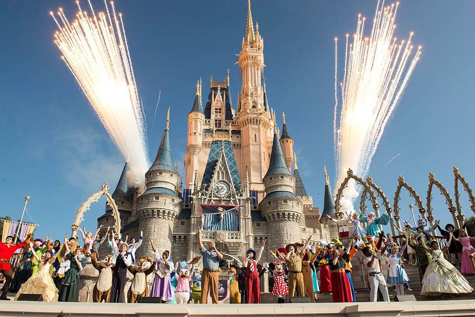 disney characters in front of cinderella's castle at walt disney world with fireworks in background