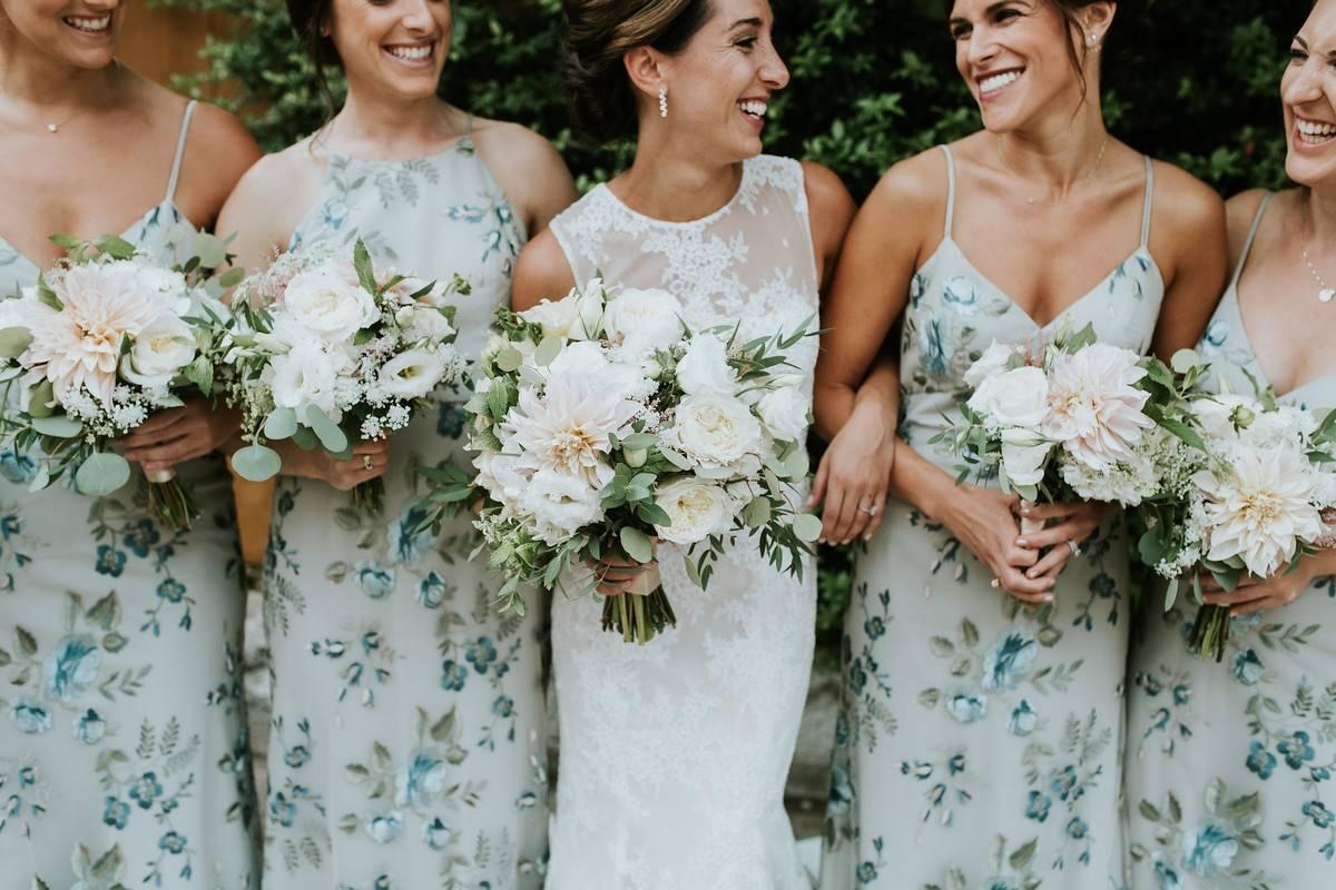 Close up of bride and her bridesmaids wearing pastel floral bridesmaid dresses