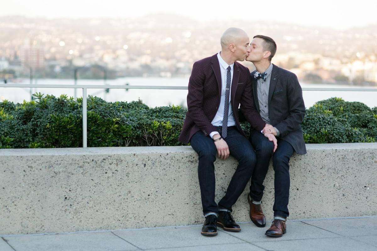 gay couple kissing with scenic water view behind them