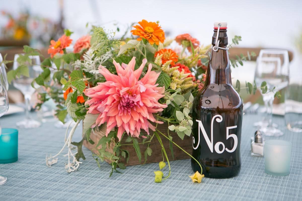 Wildflower nature wedding centerpieces with wood slices, bottles
